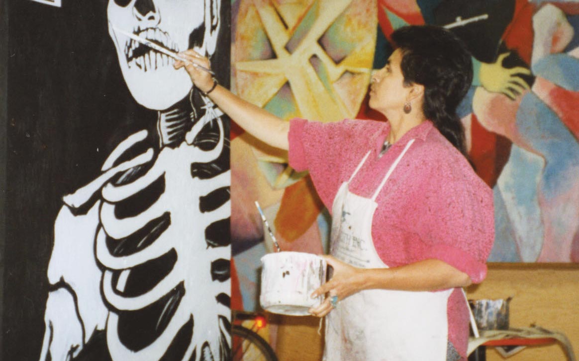 painting a mural during Day of the Dead