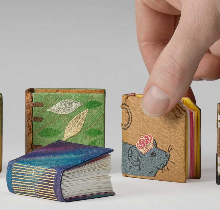 Back row, left to right: Joseph Coelho, An Abecedarius of the Very Teeny: and other poems, bound by Matthew Stockl, Royal Bindery; Sir Ben Okri, Poems, bound by Rachel Ward-Sale, Bookbinders of Lewes; Dame Jacqueline Wilson, The House Mouse / translated from Mouse Squeaks, bound by Eri Funazaki; A. N. Wilson, The Residents: a poem, bound by Peter Jones; In front: Lucy Caldwell, Intimacies, bound by Gillian Stewart, Juju Books.