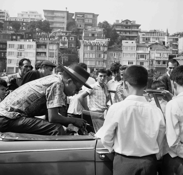 James Baldwin sitting in a Triumph Herald on the Bosporus Ferry